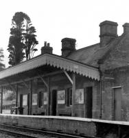 008 Shillingstone Station 1960s.
Note 1) wide platform gardens and smaller rear hedge on left.
2) maturity of the iconic cypress fir tree.
3) layout of 5 wall advertisements under thecanopy and one under the goods entrance on the right.